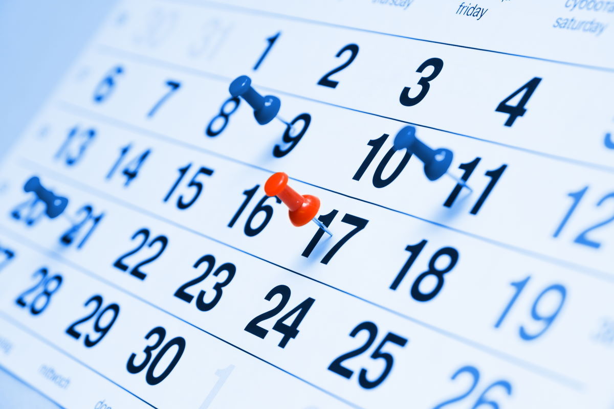 A wall calendar with pins marking key campaign dates