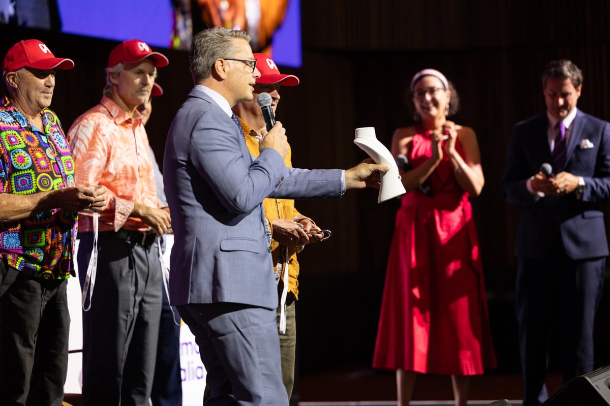 A key challenge winner on stage attempting their key during Myeloma Australia's live unlocking ceremony