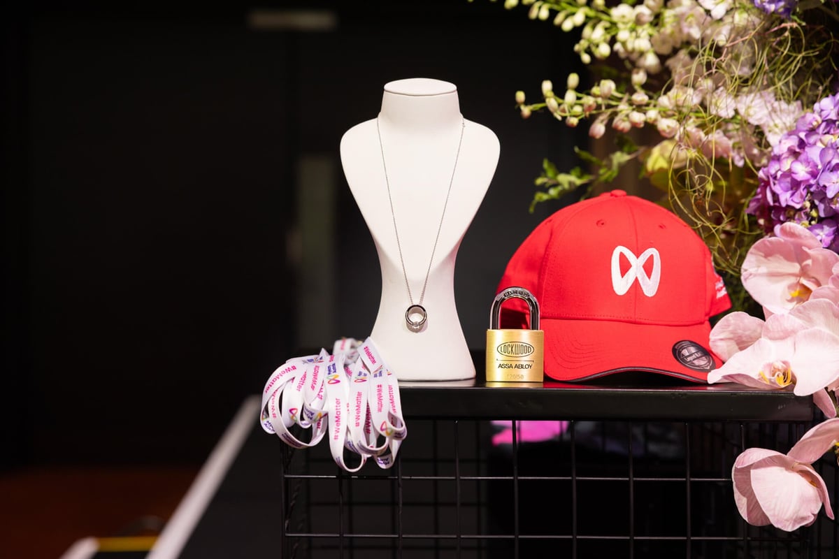 Myeloma Australia's prize display — the diamond pendant on a stand beside a branded cap, padlock and #WeMatter lanyards