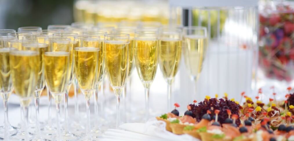 Rows of champagne flutes and canapés at a corporate High Tea fundraising event